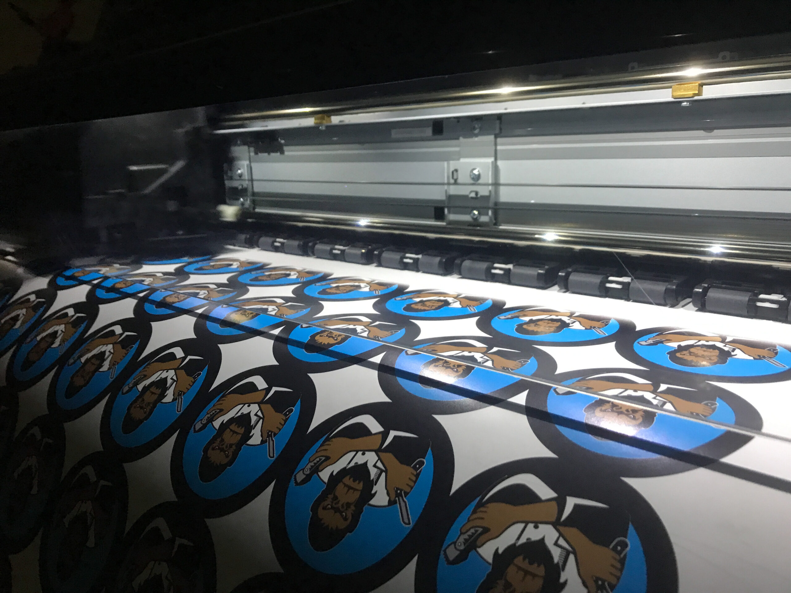 circular logo stickers coming out of a printer.